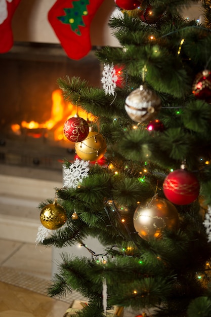 Kamin mit brennenden Holzscheiten weihnachtlich dekoriert