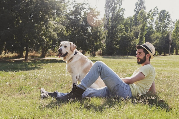 Kanadischer Labrador-Hund ruht sich an einem sonnigen Tag mit seinem Besitzer im Park aus