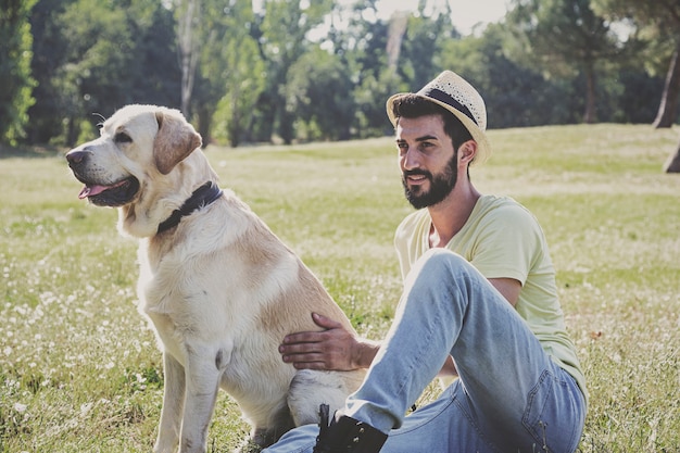 Kanadischer Labrador-Hund ruht sich an einem sonnigen Tag mit seinem Besitzer im Park aus