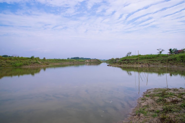 Kanal mit grünem Gras und Vegetation, die sich im Wasser in der Nähe des Flusses Padma in Bangladesch widerspiegeln