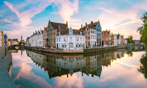 Kanal Spiegelrei, Brücken und Touristenboot bei Sonnenuntergang in Brügge, Belgien