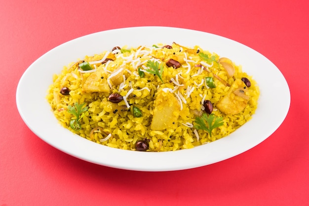 Foto kande pohay o aloo poha es una popular receta de desayuno indio hecha con arroz aplanado, generalmente servido con té caliente. servido en un bol encima. enfoque selectivo