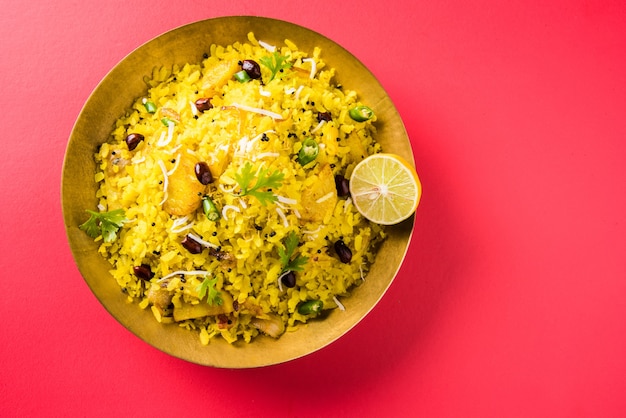 Kande Pohay OU Aloo Poha é uma receita popular de café da manhã indiano feita com arroz achatado, geralmente servido com chá quente. Servido em uma tigela. Foco seletivo