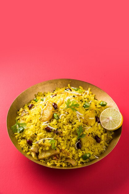 Kande Pohay OU Aloo Poha é uma receita popular de café da manhã indiano feita com arroz achatado, geralmente servido com chá quente. Servido em uma tigela. Foco seletivo