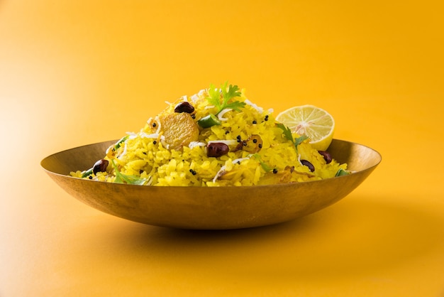 Kande Pohay OU Aloo Poha é uma receita popular de café da manhã indiano feita com arroz achatado, geralmente servido com chá quente. Servido em uma tigela. Foco seletivo