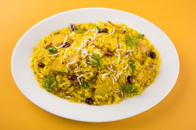 Kande Pohay OU Aloo Poha é uma receita popular de café da manhã indiano feita com arroz achatado, geralmente servido com chá quente. Servido em uma tigela. Foco seletivo