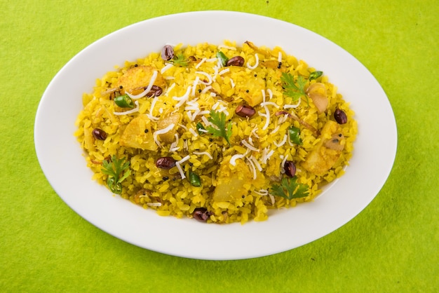 Kande Pohay OU Aloo Poha é uma receita popular de café da manhã indiano feita com arroz achatado, geralmente servido com chá quente. Servido em uma tigela. Foco seletivo