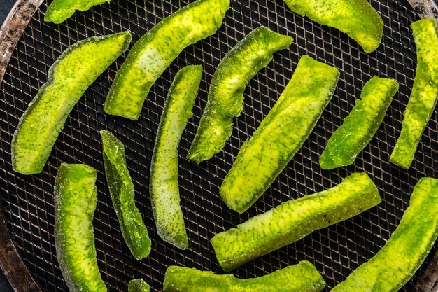 Kandierte Früchte aus einer hellgrünen Pampelmuse auf dem Grill von oben