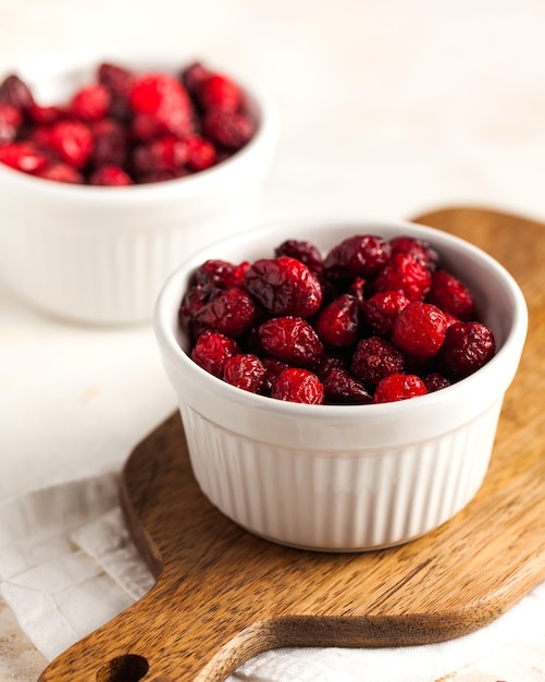 Kandierte Preiselbeeren, getrocknete Preiselbeeren Nahaufnahme in einer weißen Schüssel auf einem Holzbrett