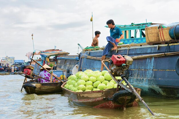 Kann Tho, Vietnam - 28. Februar 2016: Mann, der Kohl vom Boot auf dem sich hin- und herbewegenden Markt am Delta Mekong in Can Tho, in Vietnam verkauft