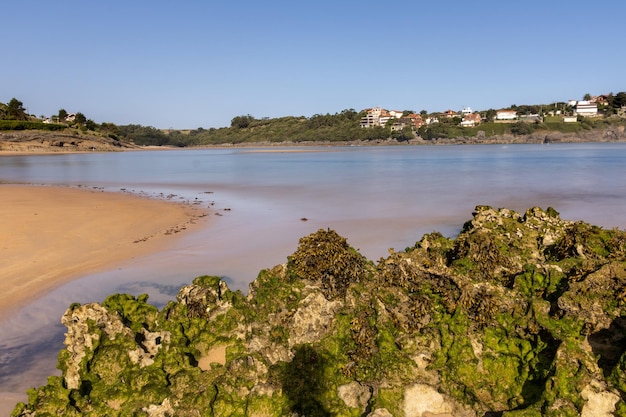 Kantabrischer Meeresstrand inmitten der Natur mit dem Meer, das in die Küste eindringt, und erodierten Felsen im Vordergrund