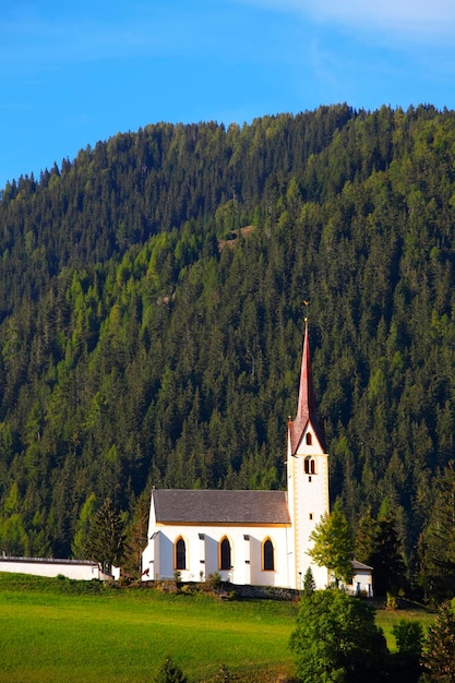 Kapelle gegen den grünen Berg gegen den blauen Himmel