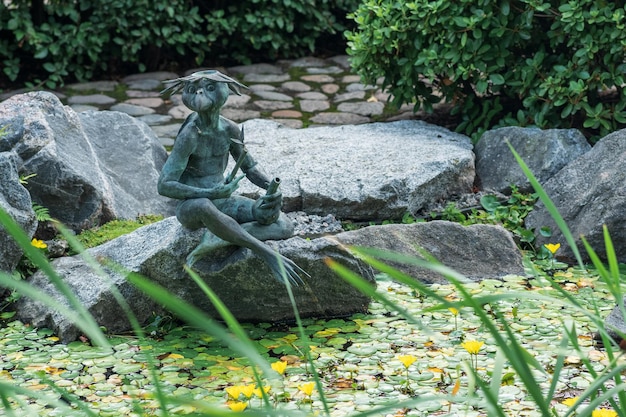 Kappa-Skulptur am Ufer eines Teiches im Japanischen Garten des Botanischen Gartens von St. Petersburg