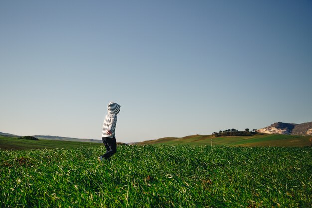 Foto kapuzenkind läuft frei im gras