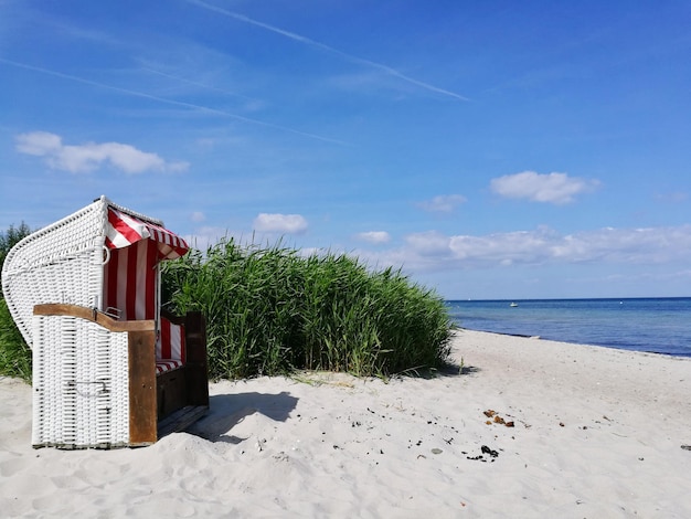 Kapuzenstühle am Strand gegen den Himmel