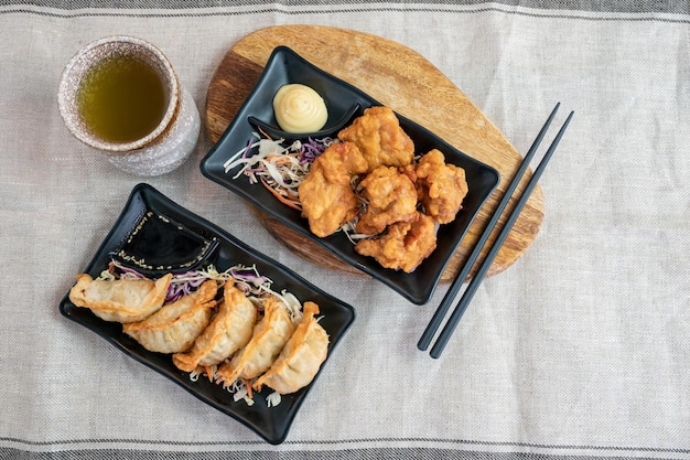 Karaage frango frito com bolinhos Gyoza e chá quente no pano