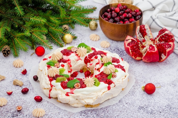 Karamell-Pavlova-Weihnachtskranz mit Kirschsauce Granatapfel-Preiselbeeren und Kiwi