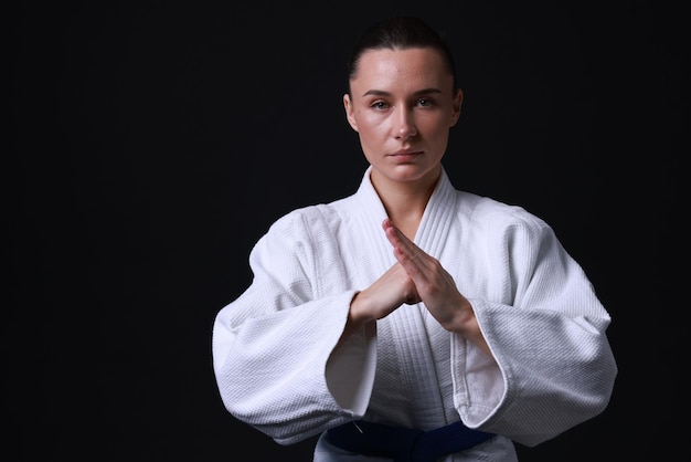Karate-Kämpfer in Kimono auf schwarzem Hintergrund