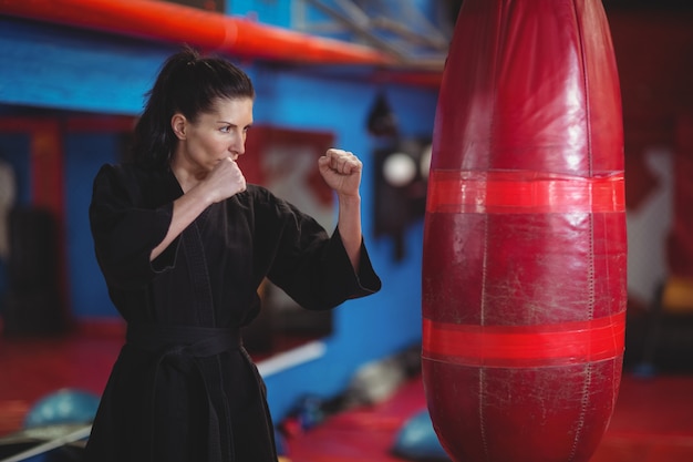 Karate-Spielerin, die das Boxen mit Boxsack übt