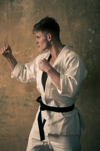 Karate-Trainer, Mann posiert in Kampfhaltung mit Fäusten