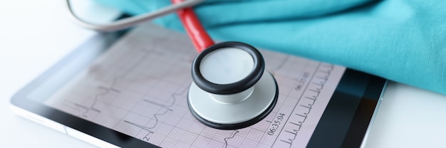 Kardiogramm-Ergebnisse und Stethoskop auf Tablet-Untersuchung des Herz-Kreislauf-Systems