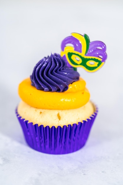 Karneval-Vanille-Cupcakes in Cupcake-Förmchen aus Folie und dekoriert mit italienischem Buttercreme-Zuckerguss.