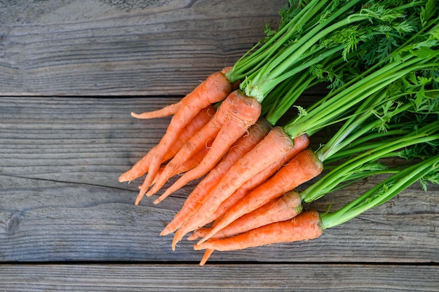 Karotte auf Tischhintergrund Frische und süße Karotten zum Kochen von Obst und Gemüse für das Gesundheitskonzept Babykarotten Bund und Blatt