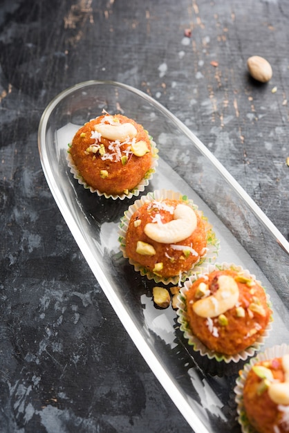 Karotte Halwa Laddu oder süße Kugeln, serviert in einem Teller mit Trockenfrüchten. selektiver Fokus