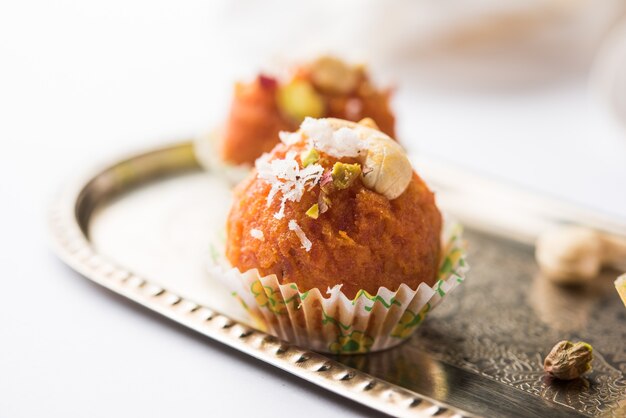 Karotte Halwa Laddu oder süße Kugeln, serviert in einem Teller mit Trockenfrüchten. selektiver Fokus