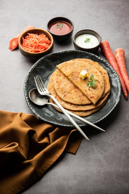 Karotte oder Gajar Ka Paratha ist ein Punjabi-Gericht, ein indisches ungesäuertes Fladenbrot aus Vollkornmehl und Karotten. Serviert mit Ketchup und Quark