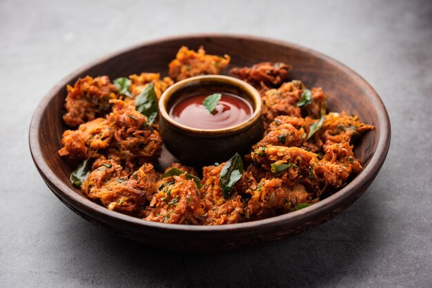 Karottenkrapfen oder Gajar ke pakore oder pakode oder bajji oder bhaji, indischer Snack auf einem Teller mit Tomatenketchup