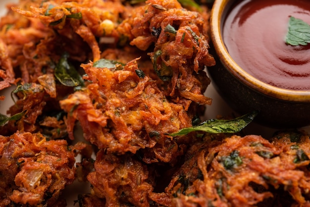 Karottenkrapfen oder Gajar ke pakore oder pakode oder bajji oder bhaji, indischer Snack auf einem Teller mit Tomatenketchup