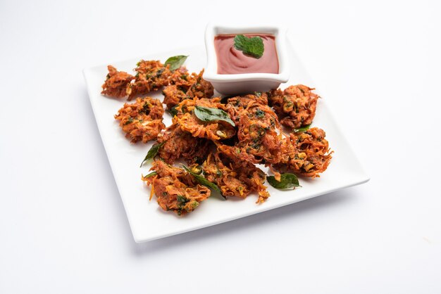 Karottenkrapfen oder Gajar ke pakore oder pakode oder bajji oder bhaji, indischer Snack serviert auf einem Teller mit Tomatenketchup