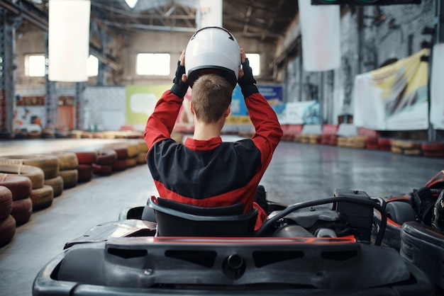 Kart Racer setzt Helm auf, Rückansicht, Karting Indoor.