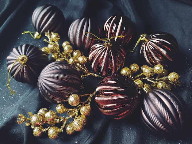 Karte für das neue Jahr und Weihnachten mit Dekorationen Weihnachtsschmuck und funkelt auf schwarzem Hintergrund Brown glänzende gestreifte Kugeln Blumen und weiße Schneeflocken goldene Zweige mit Beeren