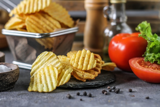 Kartoffelchips auf dem Tisch mit Zutaten herum