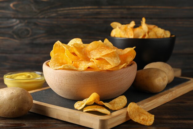 Kartoffelchips. Bier Snacks, Sauce, Kartoffel auf Schneidebrett, auf Holz, Platz für Text. Nahansicht