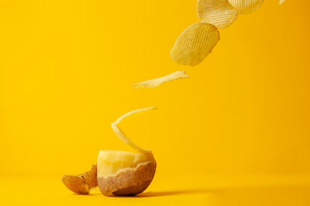Kartoffelchips fliegen auf einen gelben Hintergrund