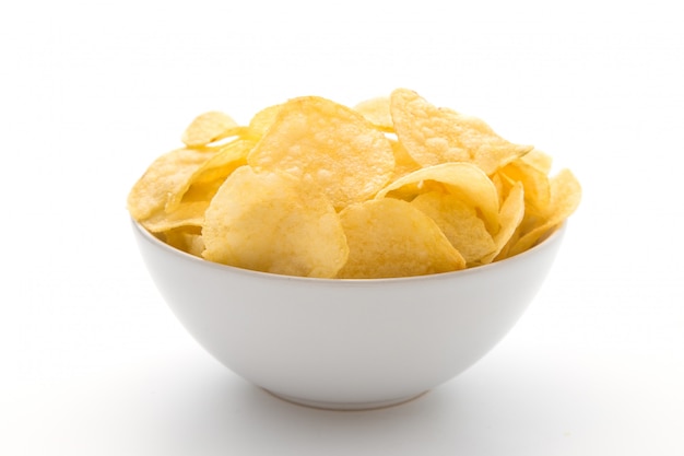 Kartoffelchips in der weißen Schüssel lokalisiert auf weißem Hintergrund.