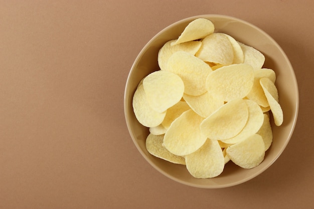 Kartoffelchips in einem Teller auf einem farbigen Hintergrund Draufsicht