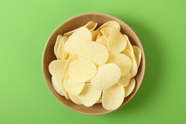 Kartoffelchips in einem Teller auf einem farbigen Hintergrund Draufsicht