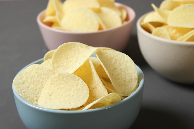 Kartoffelchips in einem Teller auf einem farbigen Hintergrund Draufsicht