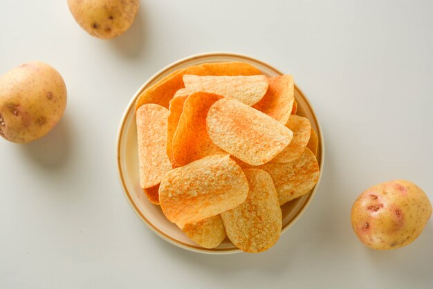 Kartoffelchips in einer Platte lokalisiert auf einem weißen Hintergrund