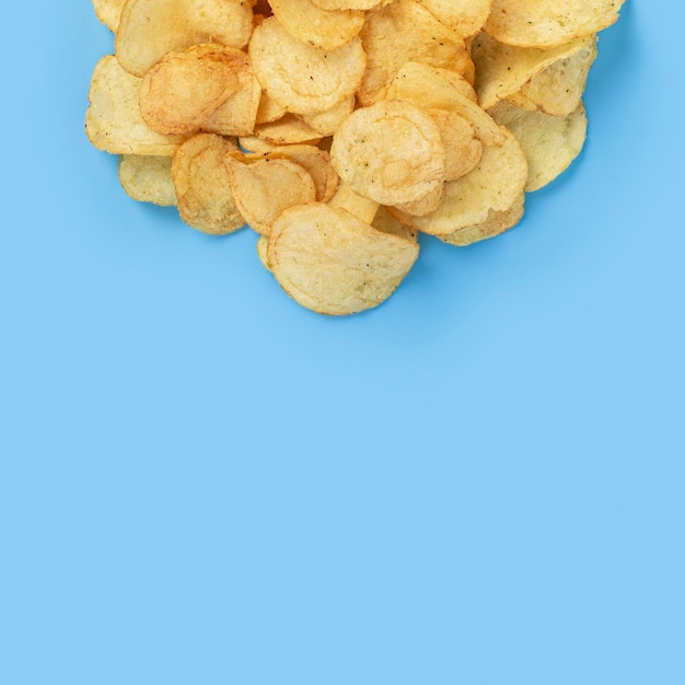 Kartoffelchips, leerer Platz für Text auf hellblauem Hintergrund. Ansicht von oben, flach.