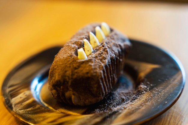 Kartoffelkuchen auf einer Untertasse Schokoladen-Rum-Kuchen Dessert dekoriert mit Sahne und Kakao-Tee-Party