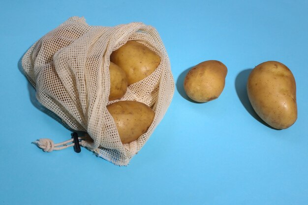 Kartoffeln im Öko-Baumwollbeutel auf blauem hellem Hintergrund