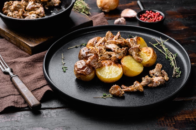 Kartoffeln mit Pilzen eingestellt, auf altem dunklem Holztischhintergrund