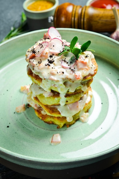 Kartoffelpfannkuchen mit Sahnesauce ukrainisches Gericht auf schwarzem Hintergrund Freier Platz für Text