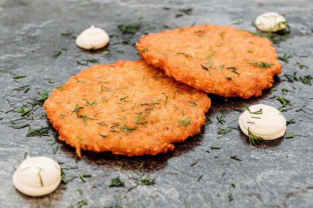 Kartoffelpfannkuchen, Soße auf dunklem Hintergrund, Cafémenü, einfaches nationales slawisches Lebensmittel