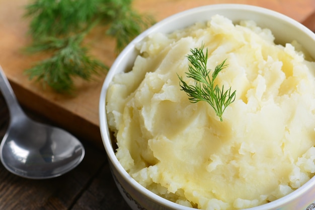 Kartoffelpüree gekochtes Püree im Keramiktopf auf Holzuntergrund